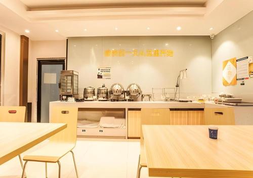 a large kitchen with tables and chairs in a room at City Comfort Inn Liuzhou The Mixc Xijiang Road in Liuzhou
