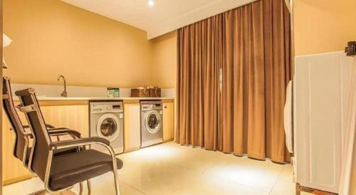 a laundry room with a chair and a washing machine at City Comfort Inn Liuzhou The Mixc Xijiang Road in Liuzhou