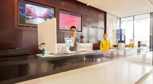 two men sitting at a counter in a store at City Comfort Inn Liuzhou The Mixc Xijiang Road in Liuzhou