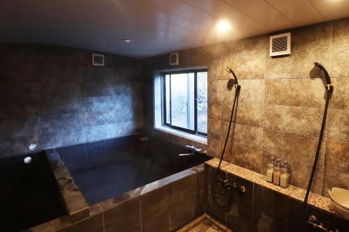 a bathroom with a shower and a sink and a window at POND CABIN Myoko - Vacation STAY 15921 in Myoko