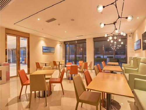 a restaurant with tables and chairs and windows at City Comfort Inn Liuzhou Wuling Liutai Road in Liuzhou