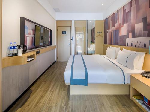 a hotel room with a large bed and a bathroom at City Comfort Inn Liuzhou Wuling Liutai Road in Liuzhou