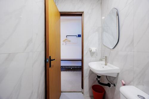 a bathroom with a sink and a mirror at Sans Vibes 4 5 Hotel in Blentuk Dua