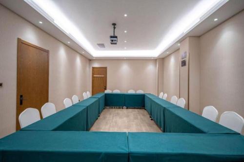 a conference room with a long table and white chairs at James Joyce Coffetel Shijiazhuang the Mixc Jinyuan Tower Airport Bus in Shijiazhuang
