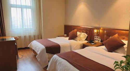 a hotel room with two beds in a room at James Joyce Coffetel Shijiazhuang the Mixc Jinyuan Tower Airport Bus in Shijiazhuang