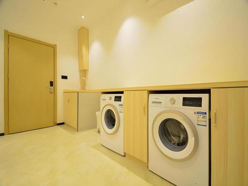 a laundry room with a washer and dryer at City Comfort Inn Shiyan Wudang Mountain in Danjiangkou