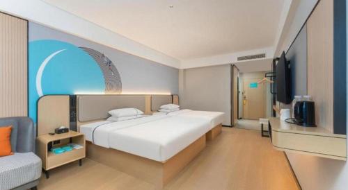 a bedroom with a large white bed and a couch at City Comfort Inn Shiyan Wudang Mountain in Danjiangkou
