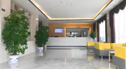 a lobby with yellow chairs and a counter in a building at GreenTree Inn Express Yingtan Yujiang Railway Station in Yingtan