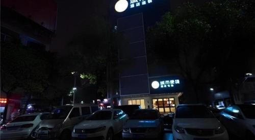 a parking lot with cars parked in front of a building at City Comfort Inn Changsha Window of the World Zhongmao City in Changsha