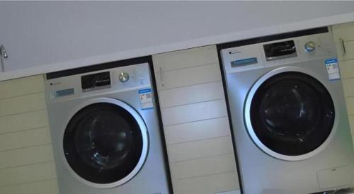 two washing machines sitting next to each other at City Comfort Inn Changsha Window of the World Zhongmao City in Changsha