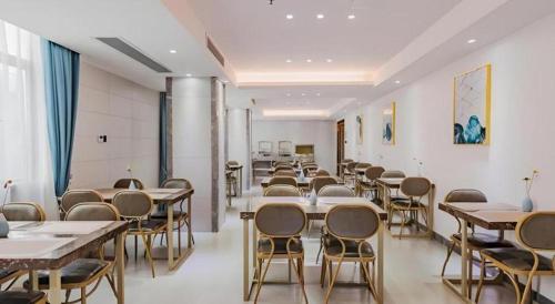 a classroom with tables and chairs in a room at Borrman Hotel Huizhou West Lake Shuidong Street in Huizhou