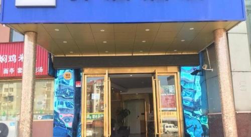 a building with a blue sign on the front of it at Ease Hotel Shanghai Chuanhuan Nan Road Chuansha Metro Station in Shanghai