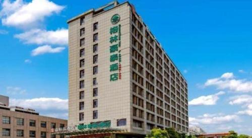 a tall building with a clock on the side of it at GreenTree Inn Anqing Yingbin Dong Road High-Speed Railway Station in Anqing