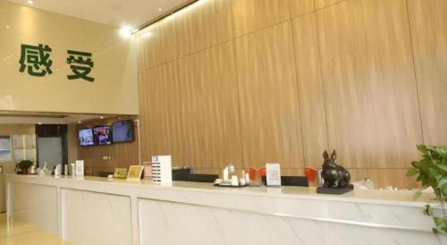 a lobby with a long counter in a building at GreenTree Inn Anqing Yingbin Dong Road High-Speed Railway Station in Anqing