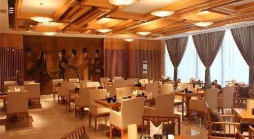 a restaurant with tables and chairs in a room at Balan International Hotel in Dujiangyan