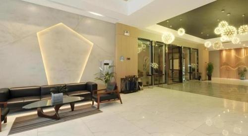 a lobby with a couch and a table in a building at VX Hotel Chengdu Shuangliu Airport Sainawei in Chengdu