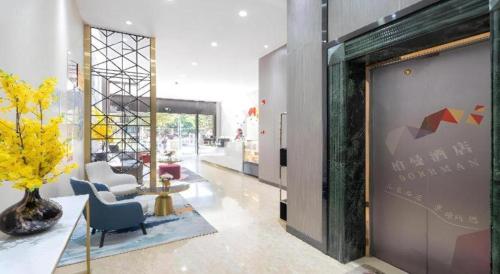 a lobby with a chair and a vase of flowers at Borrman Hotel Yuxi Yuxing Road in Yuxi