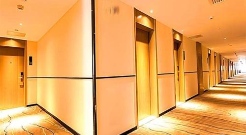 a hallway of an office building with a row of elevators at City Comfort Inn Qingyuan Longtang Light Rail Changlong in Qingyuan