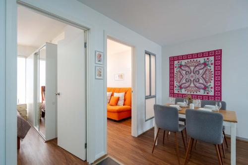 a dining room with a table and chairs and an orange couch at Stylish 2BR Brunswick Home in Melbourne