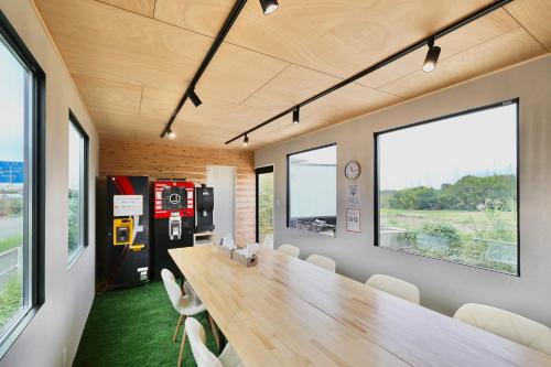 a conference room with a long wooden table and chairs at NikkaHotel東郷店 in Togo