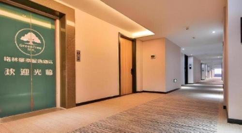a corridor of a building with a green and white wall at Green Tree Inn Express Zhejiang Zhoushan Xincheng Zheda in Zhoushan