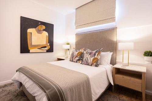 a bedroom with a bed and a painting on the wall at The Ya Ya Apartment in Stellenbosch