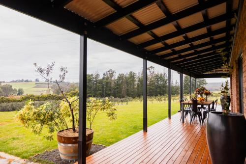 Una terraza de madera con una mesa y sillas. en The Olive Leaf Retreat, en Latrobe
