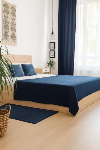 a bedroom with a bed with a blue bedspread at Chill Breeze Apartment in Stara Zagora