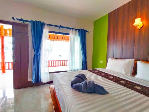 a bedroom with a large bed with blue pillows on it at Rimlay Bay View in Ko Yao Noi