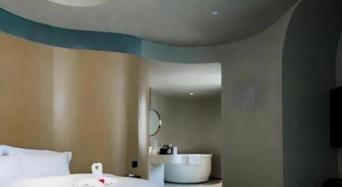 a room with a bed and a bathroom with a mirror at Borrman Hotel Jining High-tech Huangtun in Jining