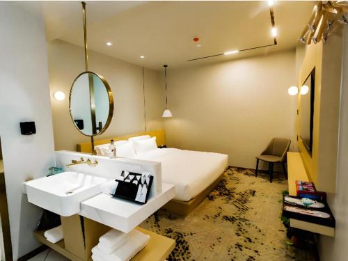a bedroom with a bed and a sink and a mirror at Borrman Hotel Jining High-tech Huangtun in Jining