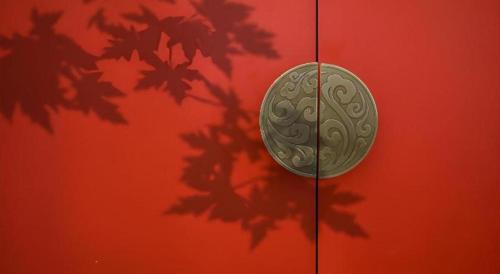 a coin is on the side of a red wall at Echeng Hotel Nanning the Mixc Convention in Nanning