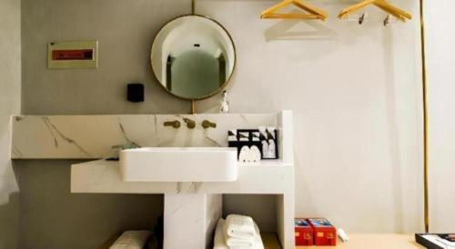 a bathroom with a white sink and a mirror at Borrman Hotel Jining High-tech Huangtun in Jining
