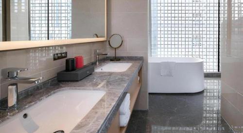 a bathroom with two sinks and a large mirror at Echeng Hotel Nanning the Mixc Convention in Nanning