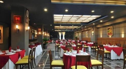 a restaurant with red and white tables and chairs at Sapadia Hotel Parapat in Parapat