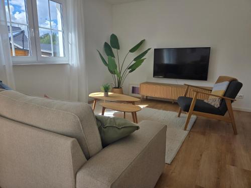 a living room with a couch and a flat screen tv at Ferienhaus am See mit Sauna in Rheinsberg