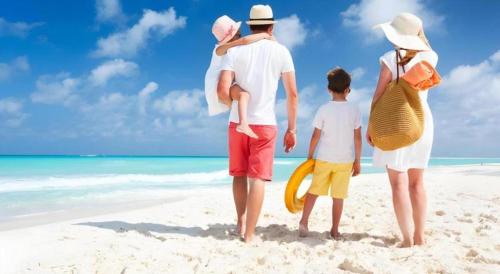 a family walking on the beach on the beach at Lotus Furnished Hotel Apartments LLC. Ajman in Ajman 