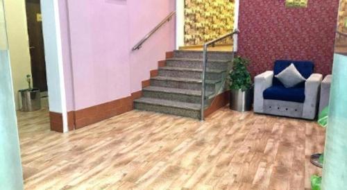 a lobby with a staircase and a blue chair at Lotus Furnished Hotel Apartments LLC. Ajman in Ajman 