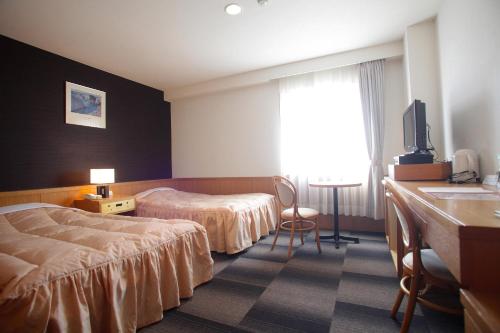 日田市にあるホテルソシアのベッド2台とテレビが備わるホテルルームです。