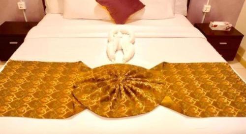 two white towels sitting on top of a bed at Lotus Furnished Hotel Apartments LLC. Ajman in Ajman 