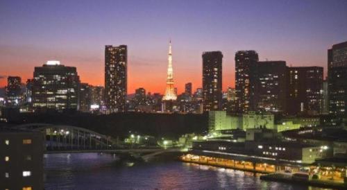 a city skyline at night with the eiffel tower at Ginza Bellevue Hotel in Tokyo