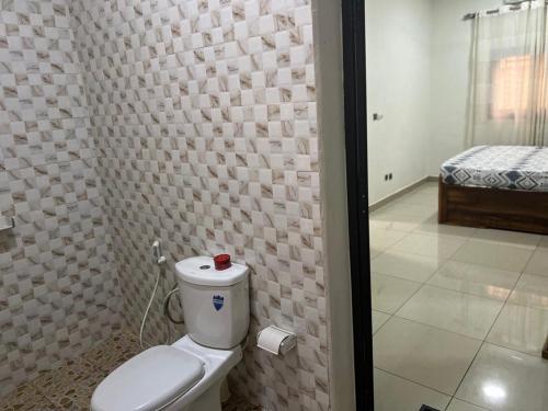 a bathroom with a white toilet in a room at Residence Alasr in Bamako
