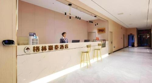 a person standing at a counter in a hospital lobby at GreenTree Inn Luoyang Henan University of Science and Technology in Luoyang