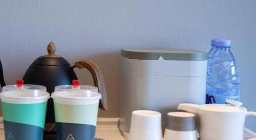 a group of cups sitting on a counter with a blender at Atour Hotel Jinan Tangyan Century Avenue in Jinan