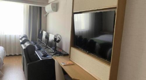 a hotel room with a large flat screen television at GreenTree Inn Luoyang Henan University of Science and Technology in Luoyang