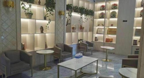 a waiting room with chairs and tables and vases at GreenTree Inn Luoyang Henan University of Science and Technology in Luoyang