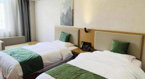 a hotel room with two beds in a room at GreenTree Inn Luoyang Henan University of Science and Technology in Luoyang