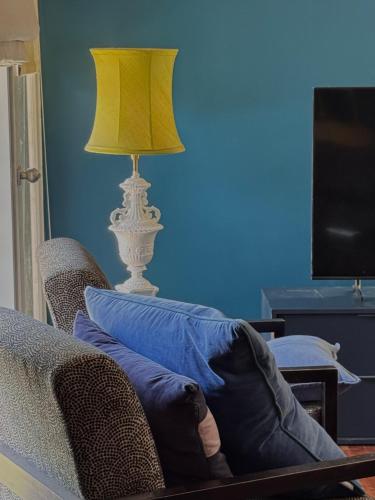 une lampe assise à côté d'un canapé avec un oreiller dans l'établissement Kingaley Farmstay, à Fosterton