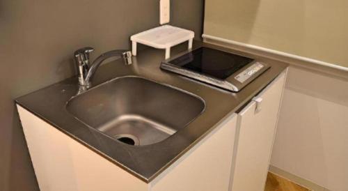 a kitchen counter with a sink with a ipod on it at HOSTEL LUND I -Oimachi- in Tokyo