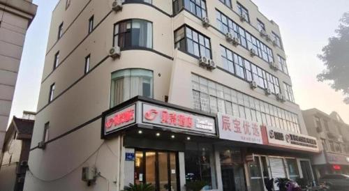 a building with a sign in front of it at Shell Hotel Wuxi Huishan District Chang'an Town in Wuxi